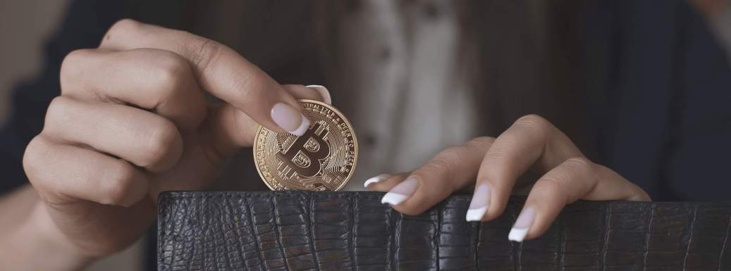 mulher colocando bitcoin dentro da carteira