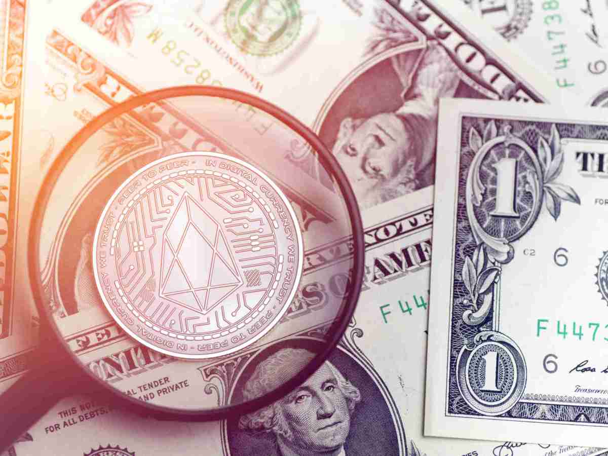 moeda eos em uma lupa no fundo moedas em dólar