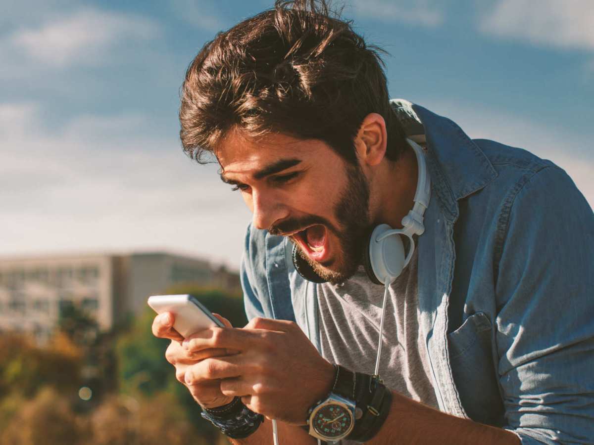 homem vendo celular portfólio de criptomoedas