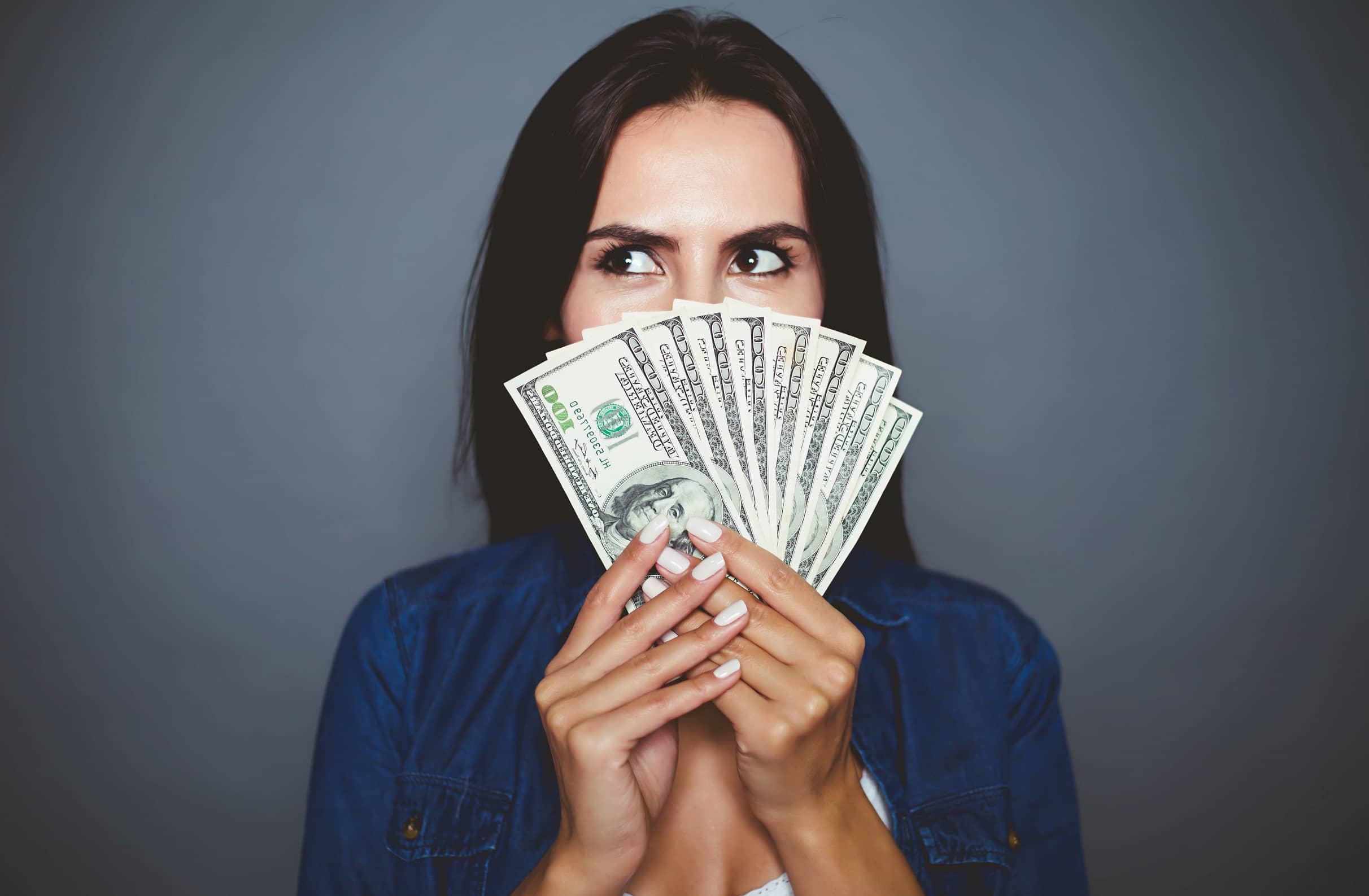 Lastro - mulher segurando notas de dólar