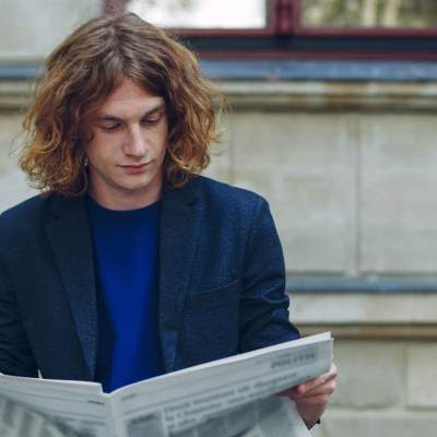 homem lendo jornal sobre bitcoin
