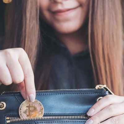 Carteiras de bitcoin online, mulher guaradando moeda de bitcoin na carteira