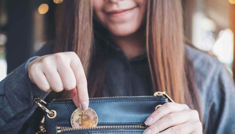 Carteiras de bitcoin online, mulher guaradando moeda de bitcoin na carteira
