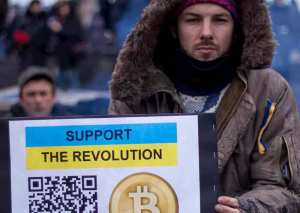 Homem segurando placa "support the revolution"