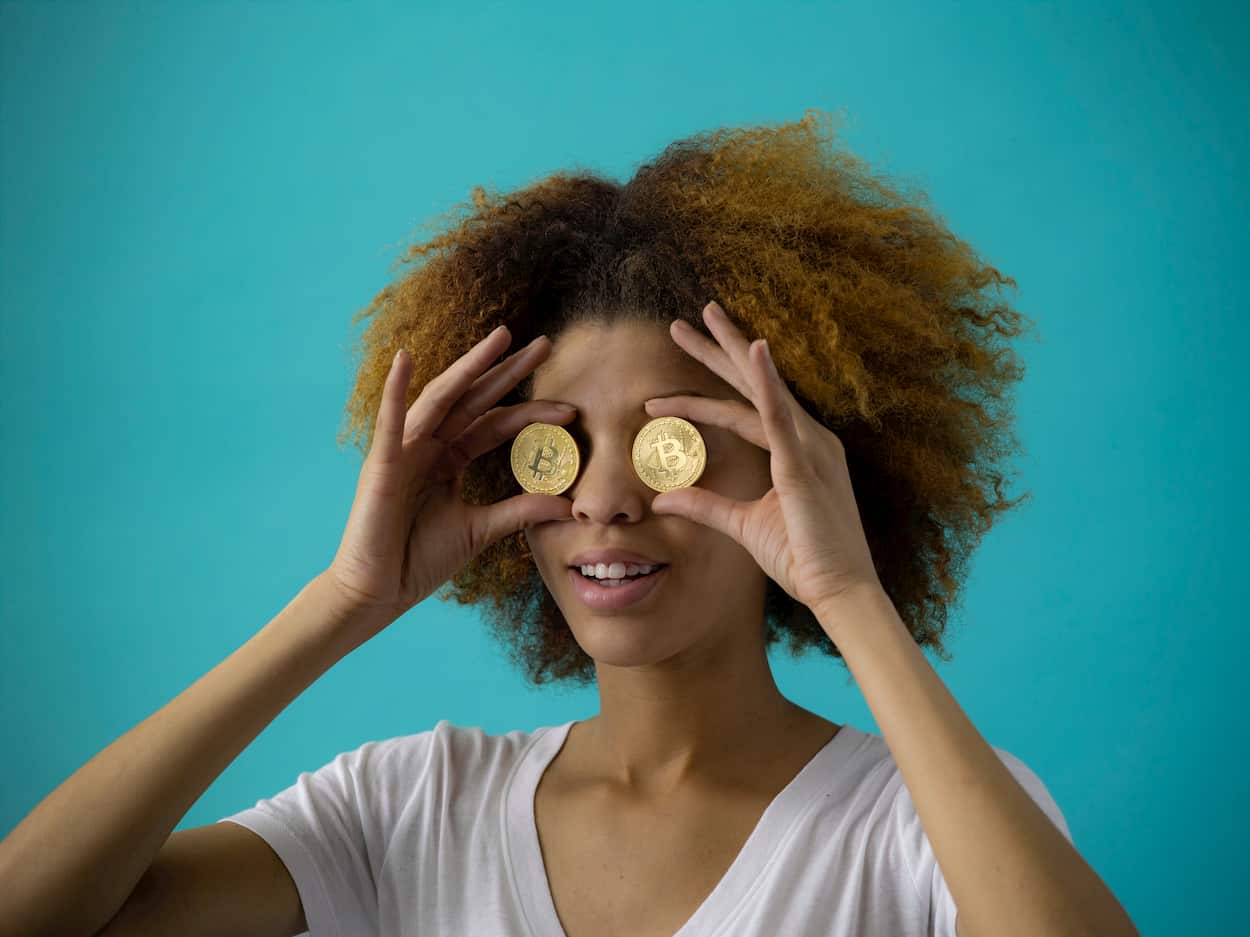 Mulher com moedas de bitcoin nos olhos