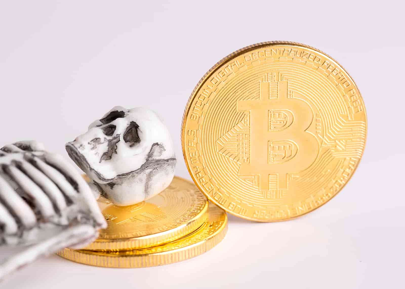 esqueleto deitado em moeda de bitcoin