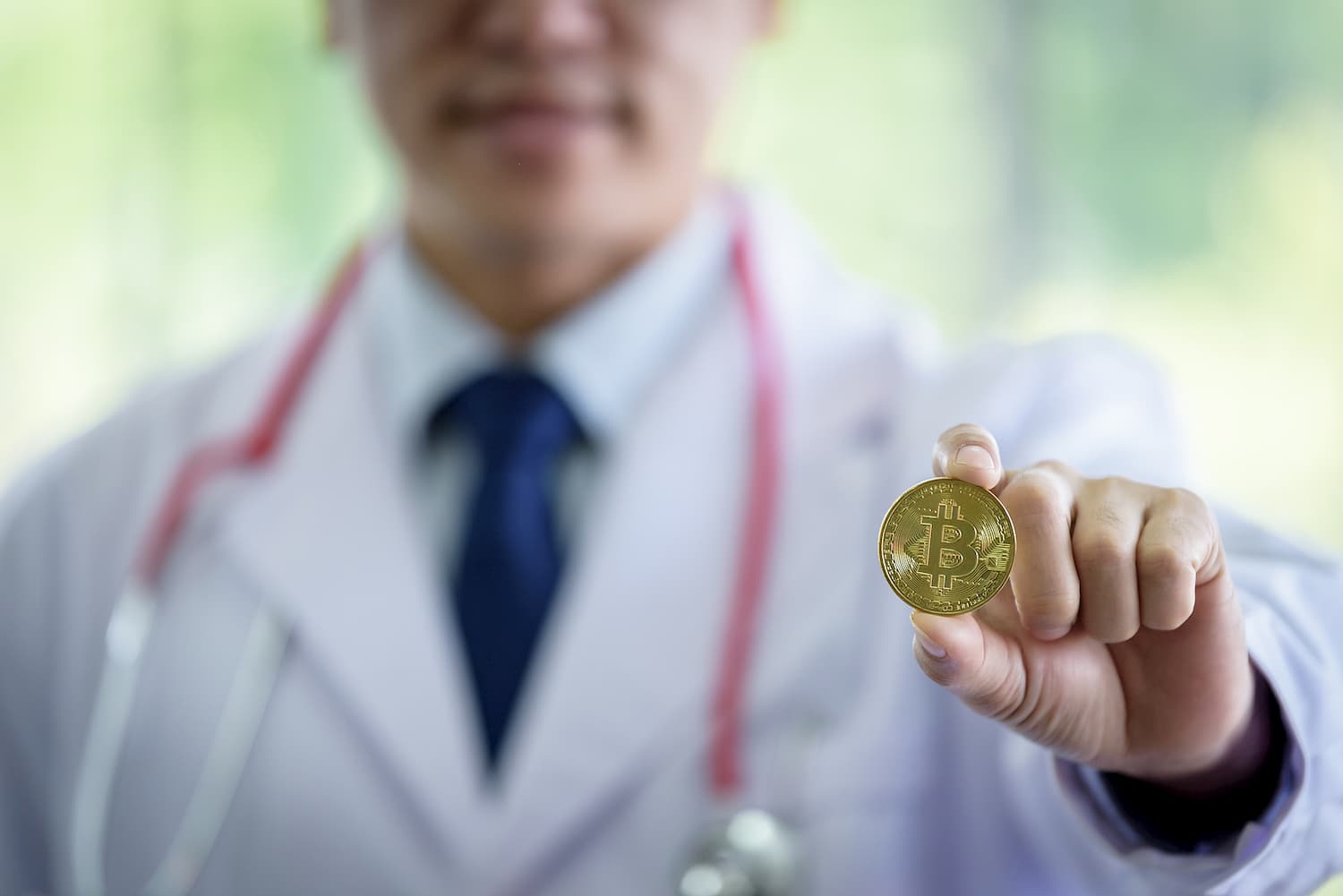 médico segurando bitcoin