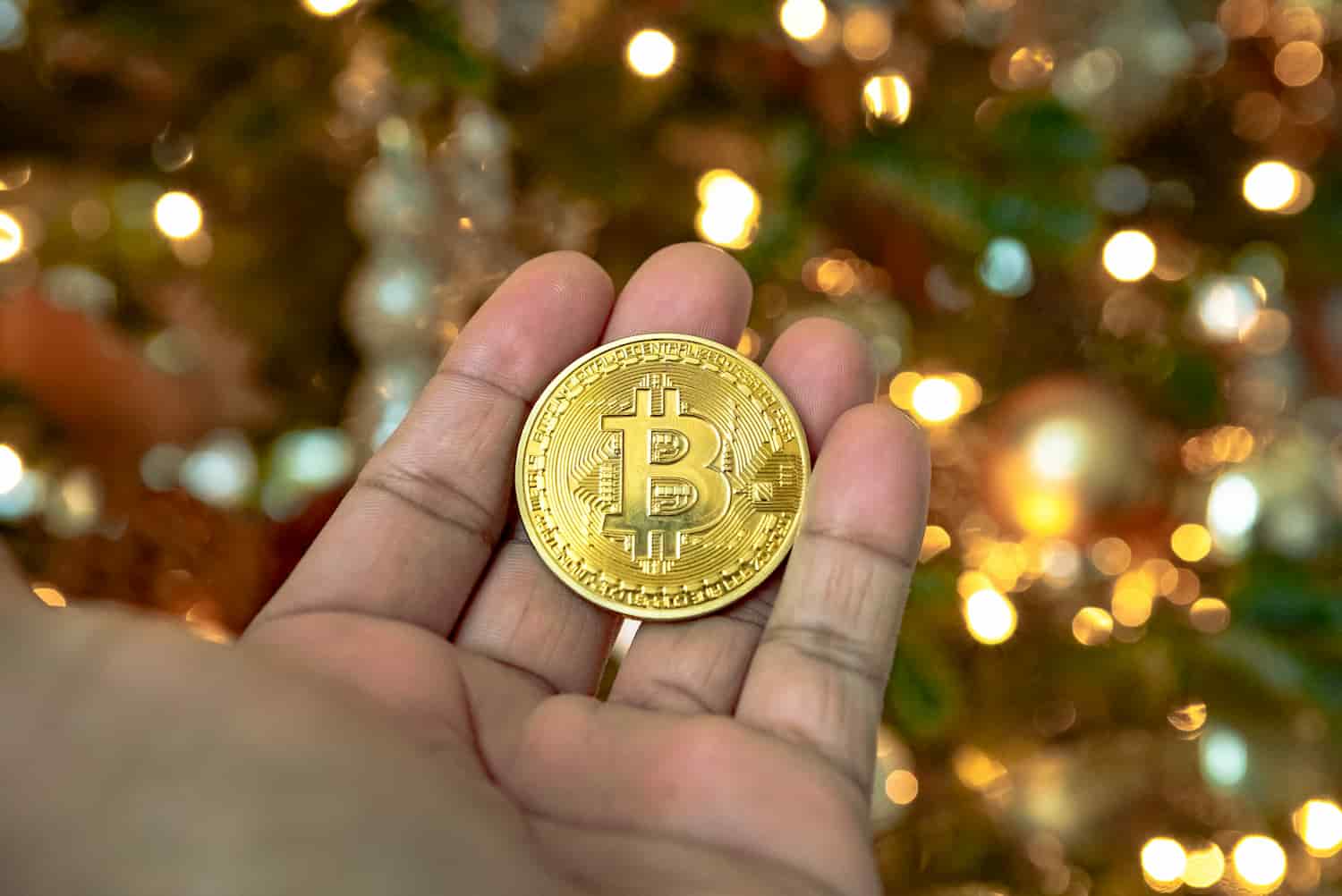 Moeda de bitcoin e fundo com luzes natalinas