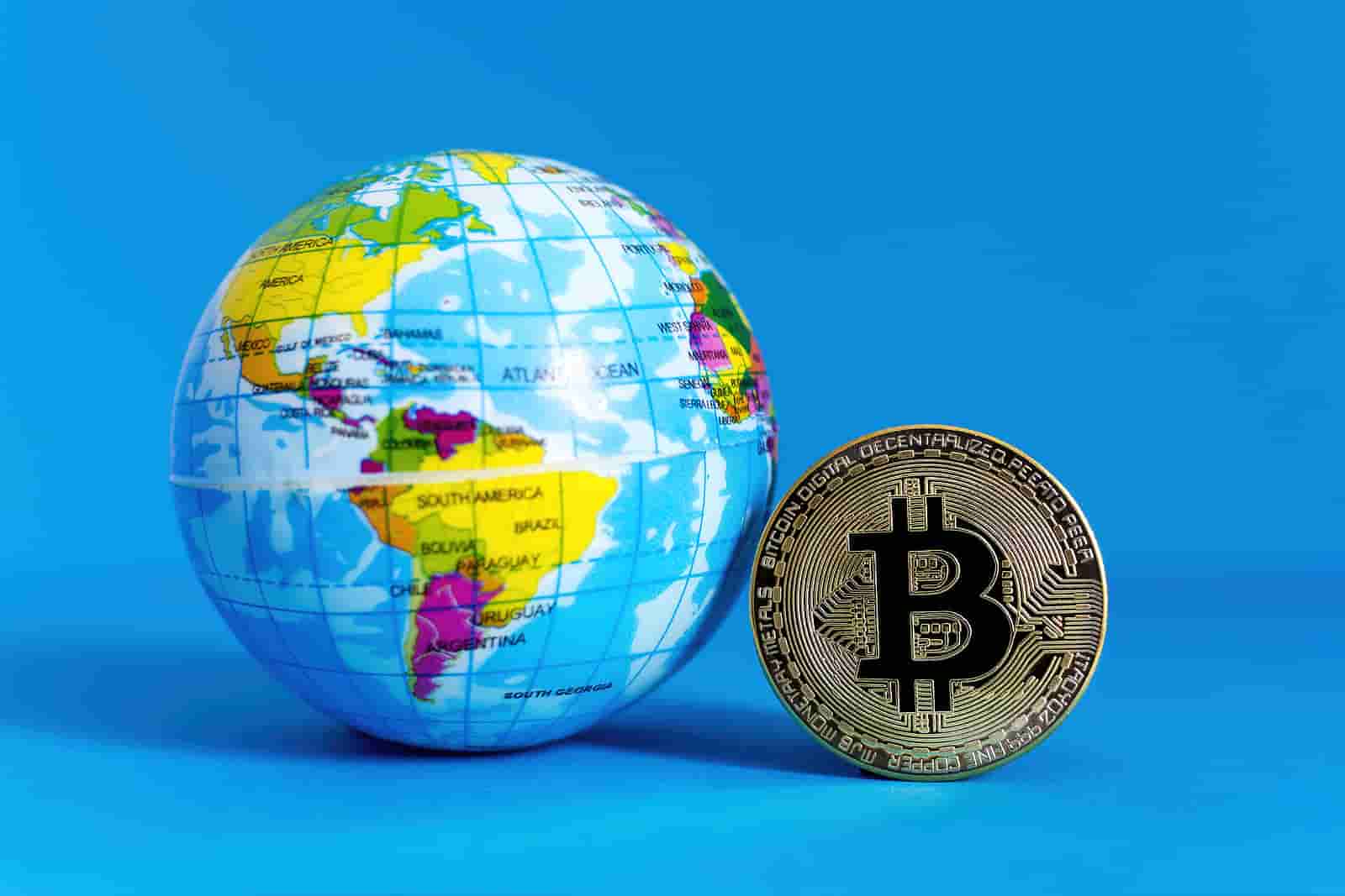 bitcoin moeda ao lado do globo