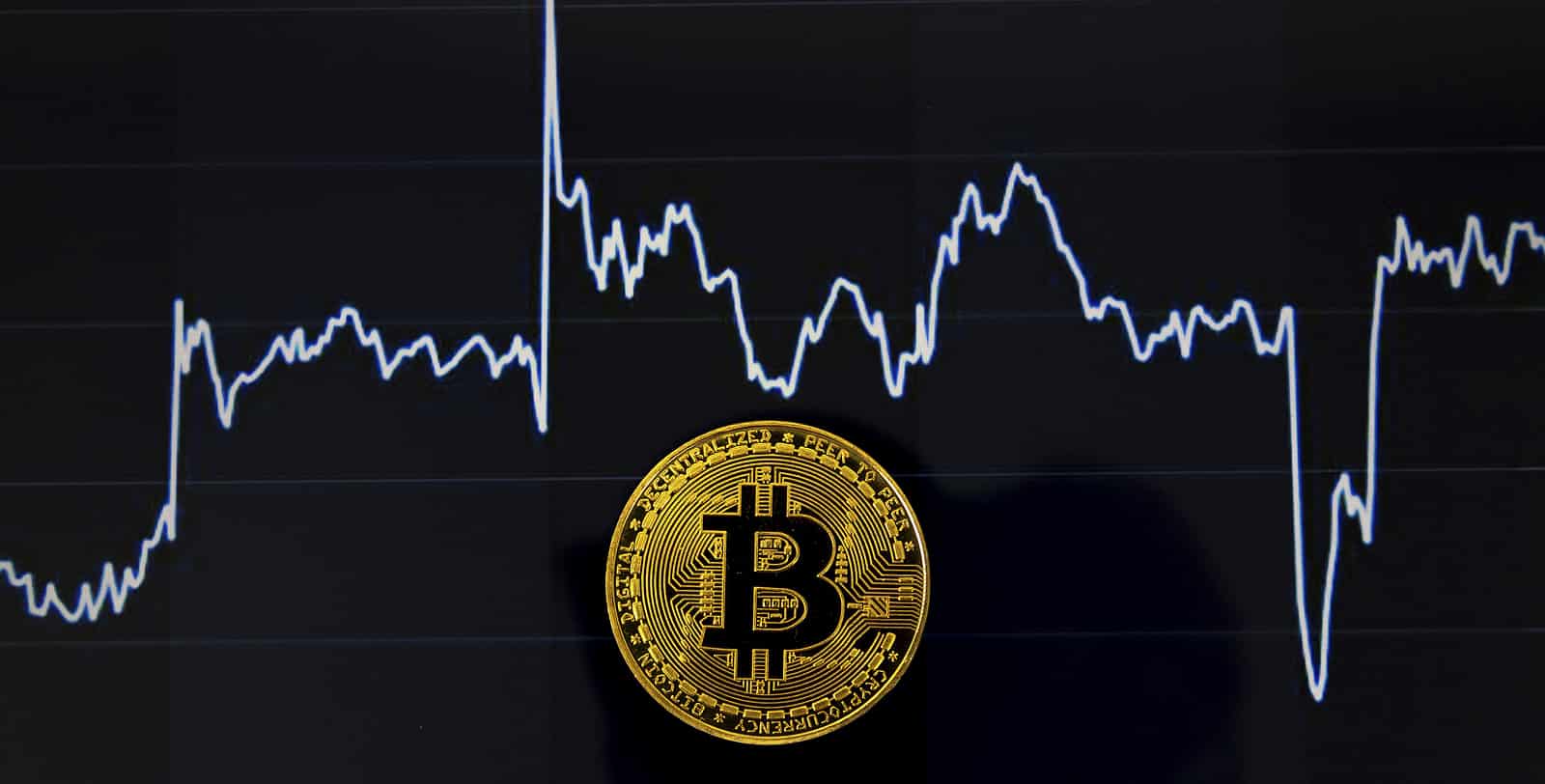 moeda de bitcoin com fundo preto e gráfico de preço atrás