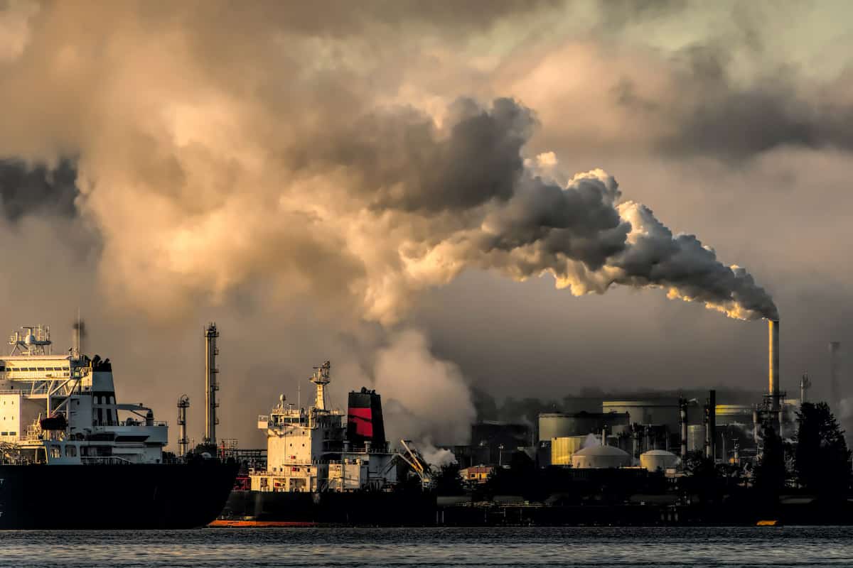 Impacto ambiental de grande empresas em um porto, chaminé saindo fumaça e céu cinza