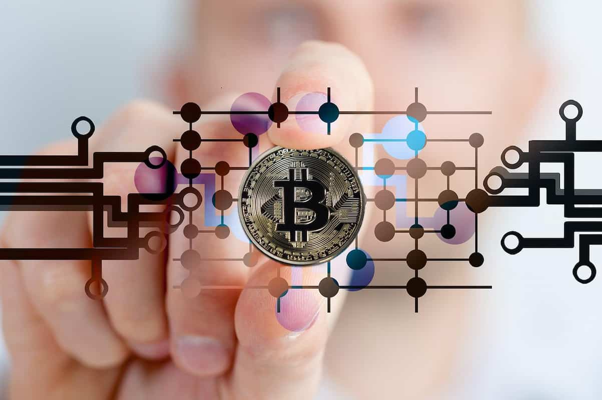 Mão segurando moeda de bitcoin