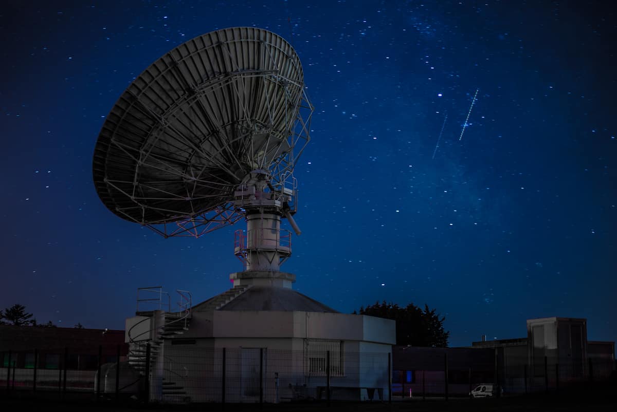 Antena de satélite com um céu noturno estrelado