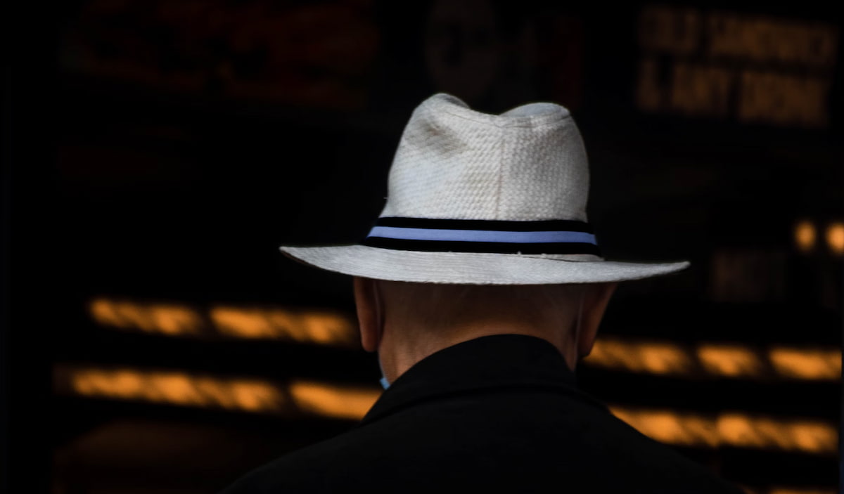 Homem com chapéu branco (white hat) em fundo tecnológico